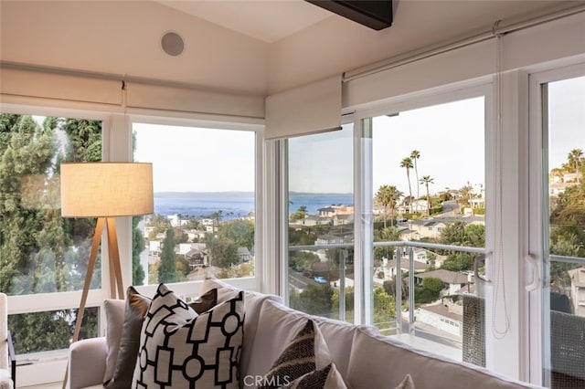 sunroom featuring a water view, lofted ceiling, and plenty of natural light