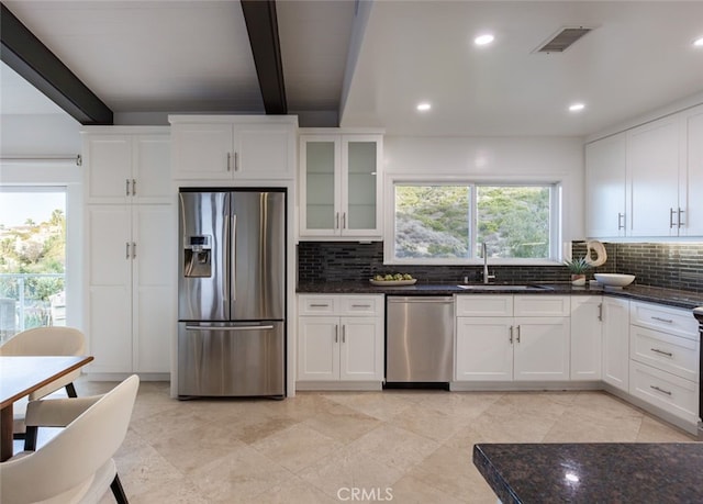 kitchen with sink, beam ceiling, stainless steel appliances, and white cabinets