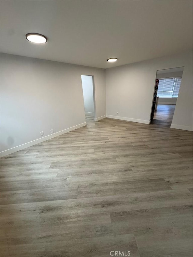 unfurnished room with baseboards and wood finished floors