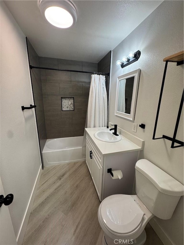 bathroom featuring vanity, toilet, shower / tub combo with curtain, and wood finished floors