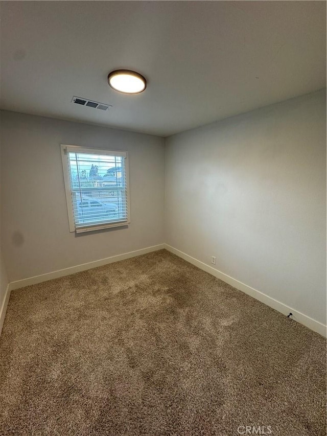 unfurnished room with visible vents, baseboards, and carpet