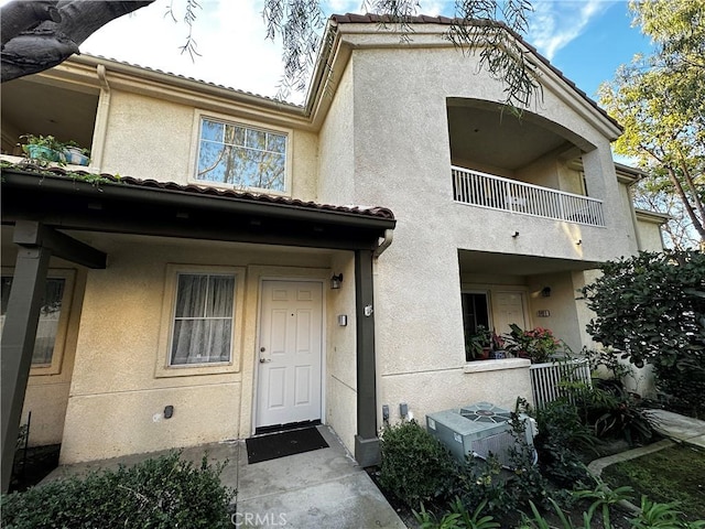 property entrance featuring a balcony and cooling unit