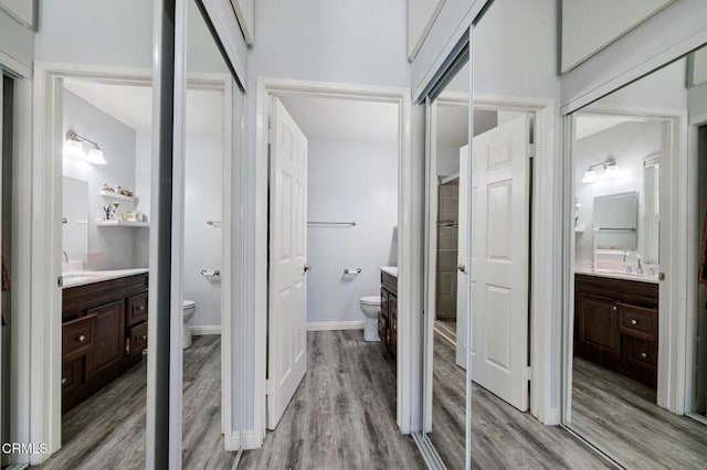 bathroom featuring wood-type flooring, toilet, and vanity