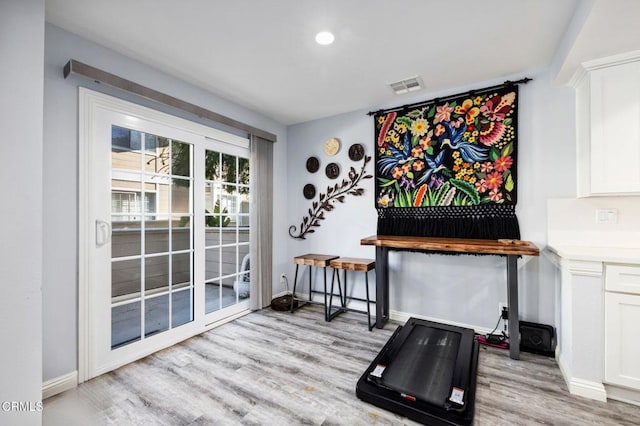 workout room featuring light wood-type flooring