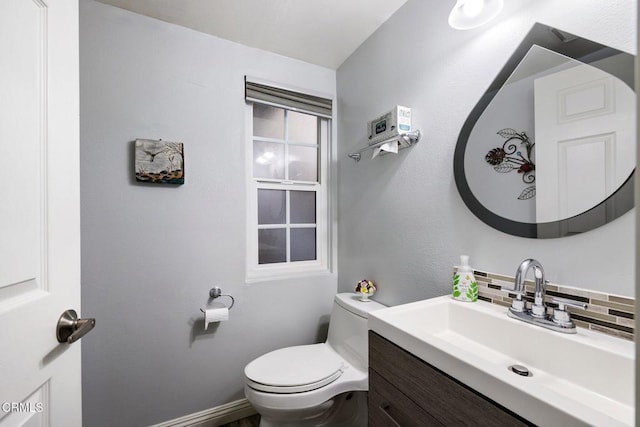 bathroom featuring backsplash, toilet, and vanity