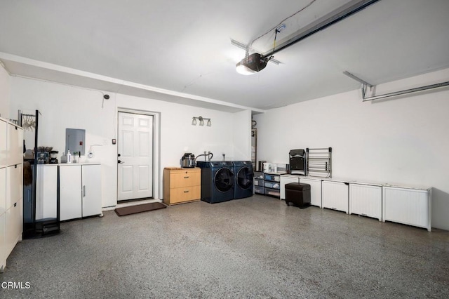 garage featuring a garage door opener, electric panel, and washer and dryer