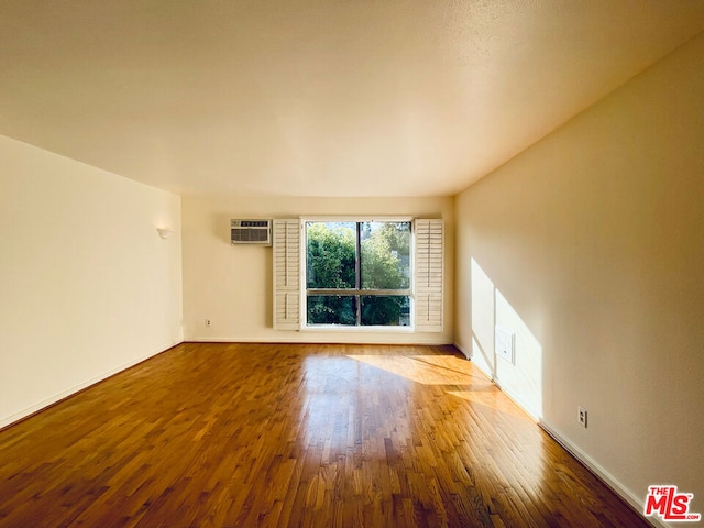 empty room with hardwood / wood-style flooring and a wall unit AC