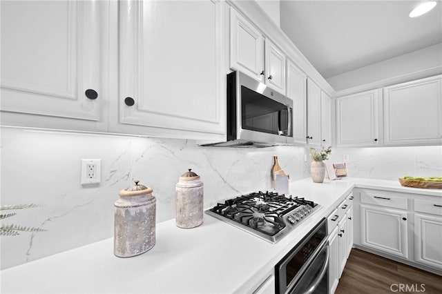 kitchen featuring white cabinetry, dark hardwood / wood-style flooring, tasteful backsplash, and stainless steel appliances