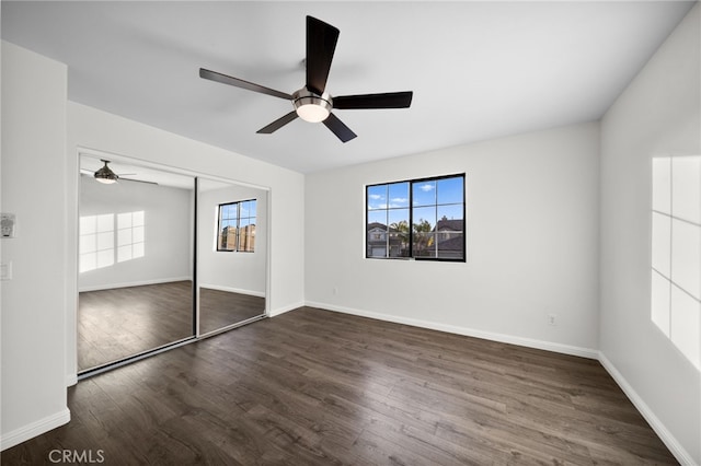 unfurnished bedroom featuring dark wood-type flooring, ceiling fan, and a closet