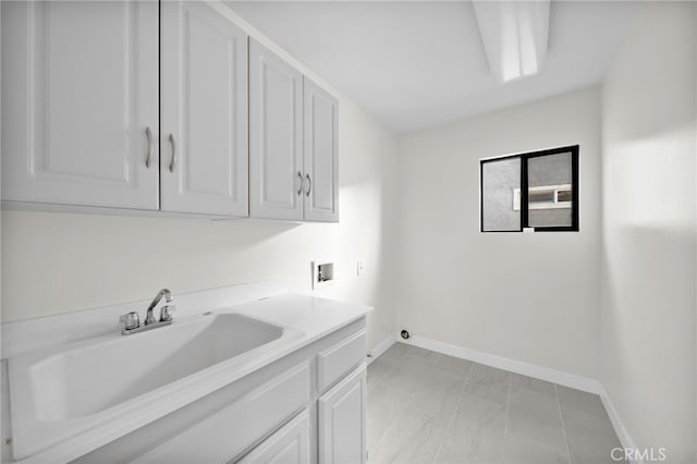 laundry room featuring sink, hookup for a washing machine, and cabinets