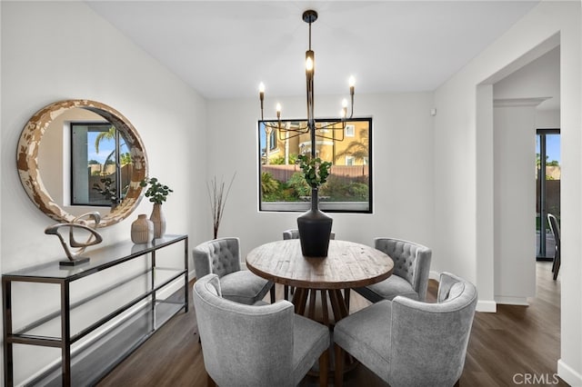 dining room featuring a notable chandelier and dark wood-type flooring