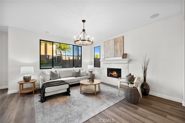 living room featuring dark hardwood / wood-style floors, a notable chandelier, and a fireplace