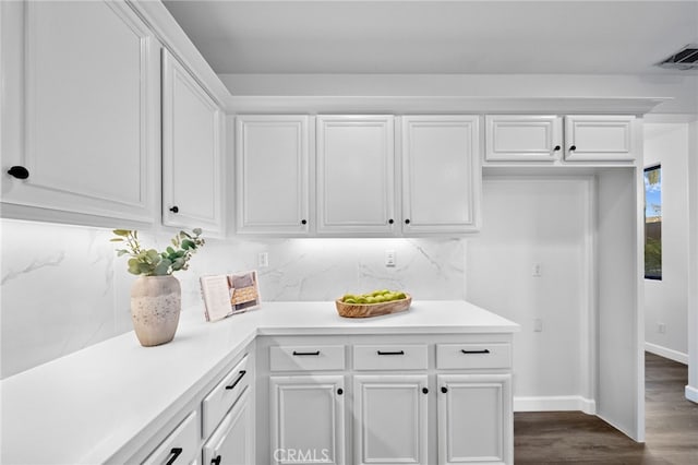 kitchen with dark wood-type flooring, decorative backsplash, and white cabinets