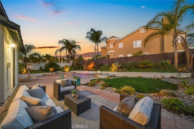 patio terrace at dusk featuring an outdoor living space