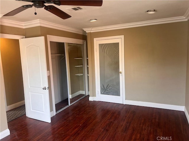 unfurnished bedroom with baseboards, crown molding, visible vents, and wood finished floors