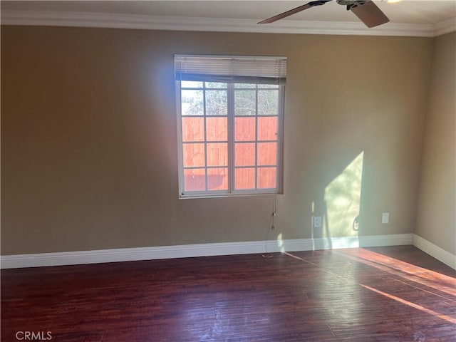 spare room featuring a ceiling fan, crown molding, baseboards, and wood finished floors