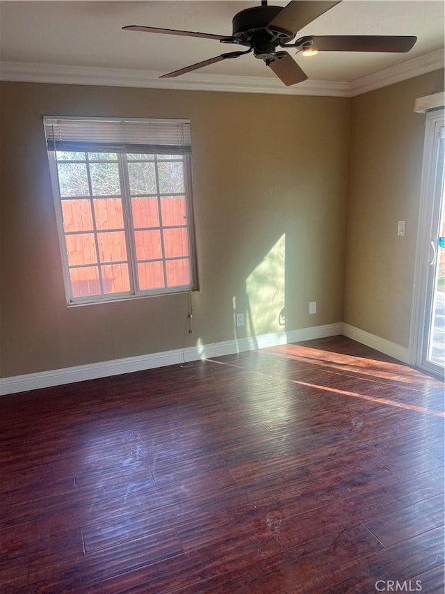 spare room with baseboards, ceiling fan, wood finished floors, and crown molding