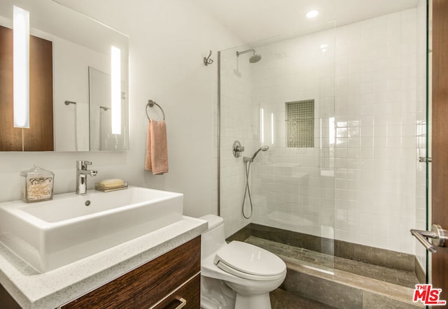 bathroom featuring vanity, toilet, and a tile shower