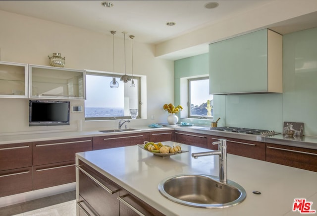 kitchen with sink, decorative light fixtures, and stainless steel gas cooktop