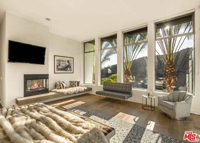 sunroom featuring a multi sided fireplace