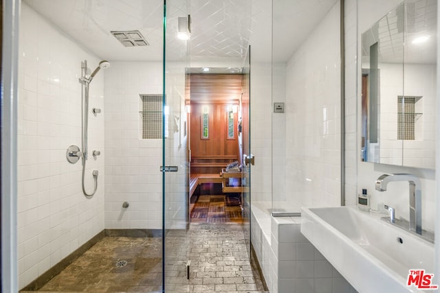 bathroom featuring sink, tile walls, and tiled shower