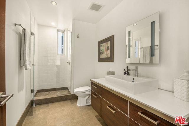 bathroom with an enclosed shower, vanity, and toilet