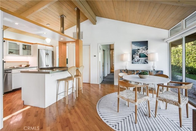 dining room with high vaulted ceiling, beam ceiling, wood ceiling, and light wood-type flooring