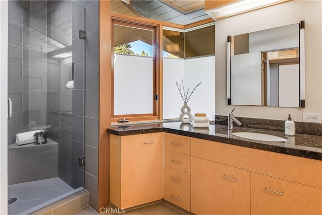 bathroom with tile patterned flooring, a shower with door, and vanity