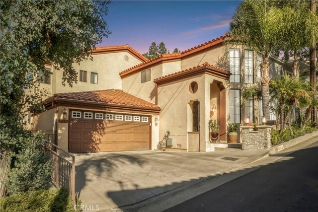 mediterranean / spanish home featuring a garage