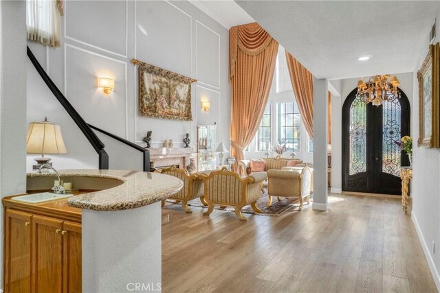 sitting room with sink, light hardwood / wood-style floors, and french doors