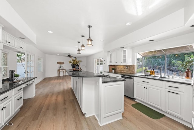 kitchen featuring dishwasher, hanging light fixtures, sink, white cabinets, and a center island