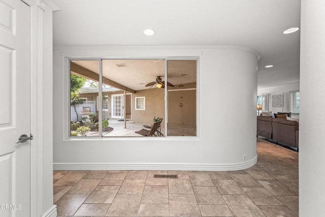 interior space featuring ceiling fan and ornamental molding