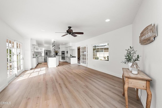 unfurnished living room featuring light wood-type flooring and ceiling fan