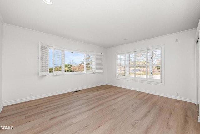 unfurnished room featuring a wealth of natural light, light hardwood / wood-style flooring, and crown molding