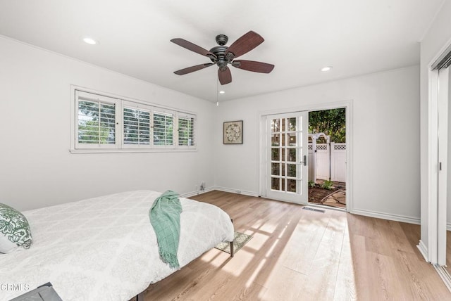 bedroom featuring light wood-type flooring, ceiling fan, and multiple windows