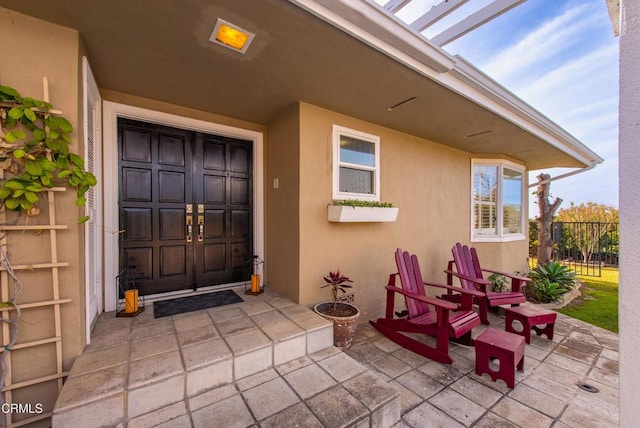 property entrance featuring a patio area and stucco siding