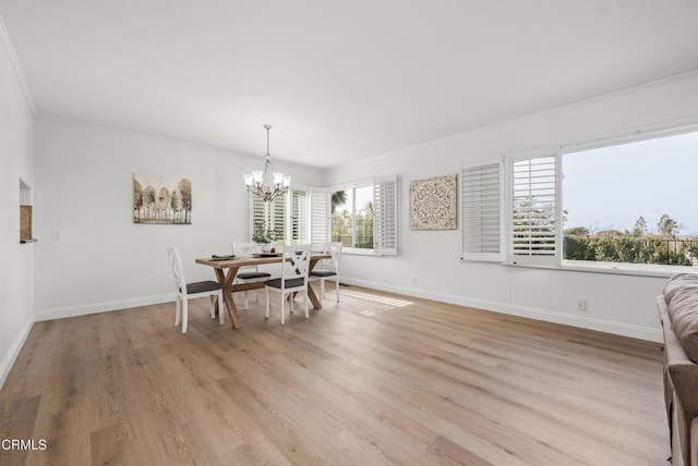 dining space with an inviting chandelier, light wood-style floors, and baseboards