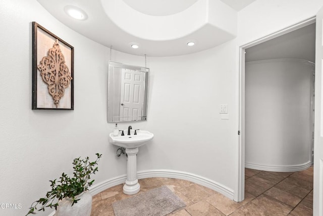 bathroom with stone finish floor, recessed lighting, and baseboards