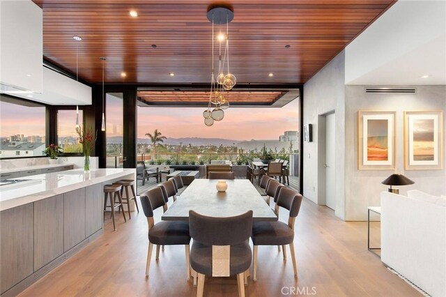 dining space with wood ceiling, floor to ceiling windows, and light wood-type flooring