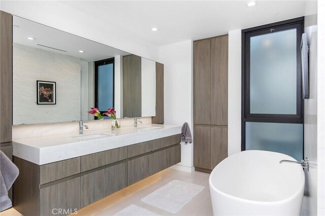 bathroom with a washtub and vanity