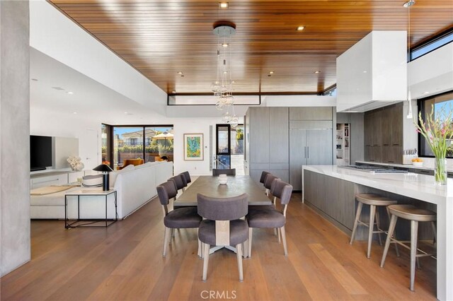 dining area featuring wood ceiling, a chandelier, and light wood-type flooring