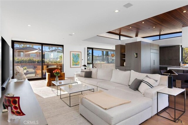 living room with floor to ceiling windows, wooden ceiling, and light hardwood / wood-style floors