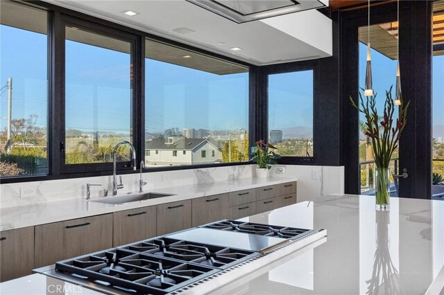 kitchen featuring stainless steel gas stove, sink, and a wealth of natural light