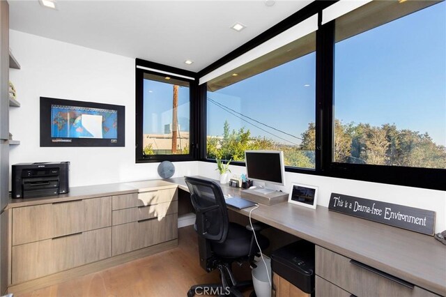 office space featuring hardwood / wood-style flooring and built in desk