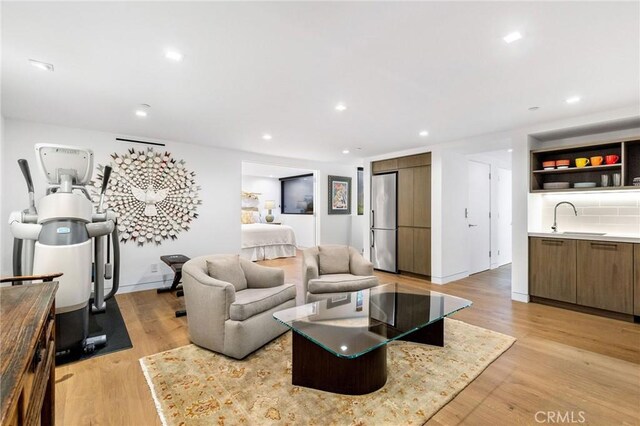 living room with light hardwood / wood-style floors and indoor wet bar