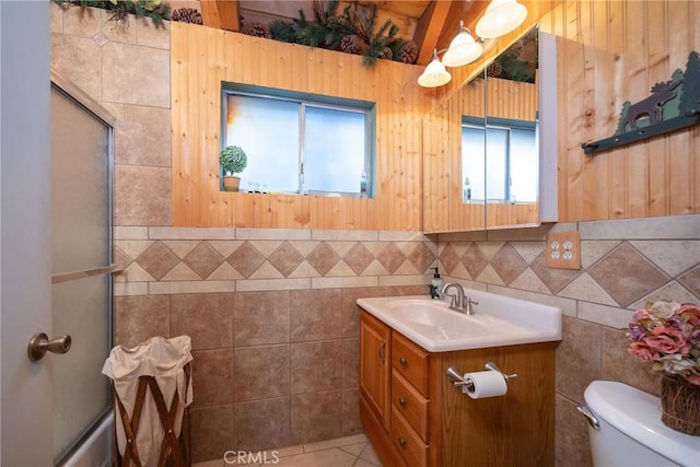 bathroom with walk in shower, vanity, toilet, and tile patterned flooring