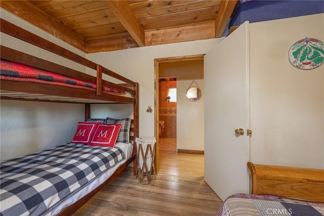 bedroom featuring hardwood / wood-style flooring, wooden ceiling, and beamed ceiling