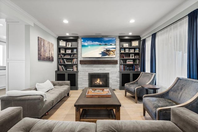 living room featuring crown molding, built in features, a fireplace, and light hardwood / wood-style floors