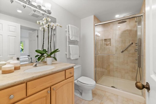 bathroom featuring radiator, a shower with shower door, tile patterned flooring, vanity, and toilet