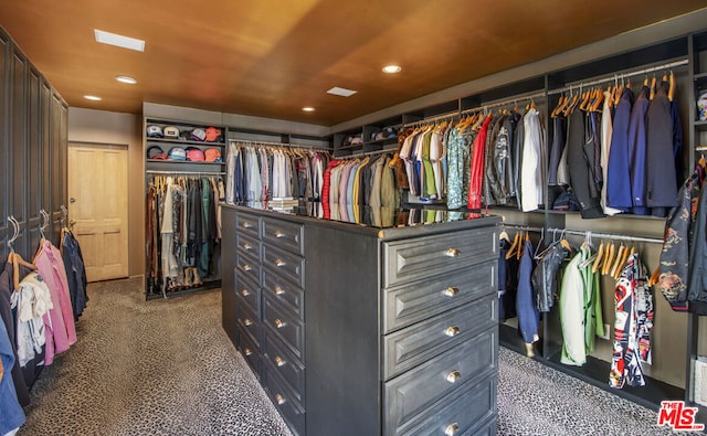 walk in closet featuring dark carpet